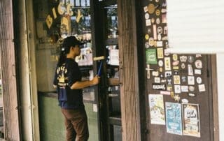 Technicien nettoyant les vitres d'une devanture commerciale avec une raclette